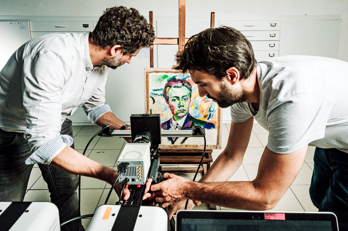 Installation d’une caméra particulière, un imageur multispectral de photoluminescence, par deux chimistes du patrimoine ; au fond on voit un tableau de R. Delaunay.
