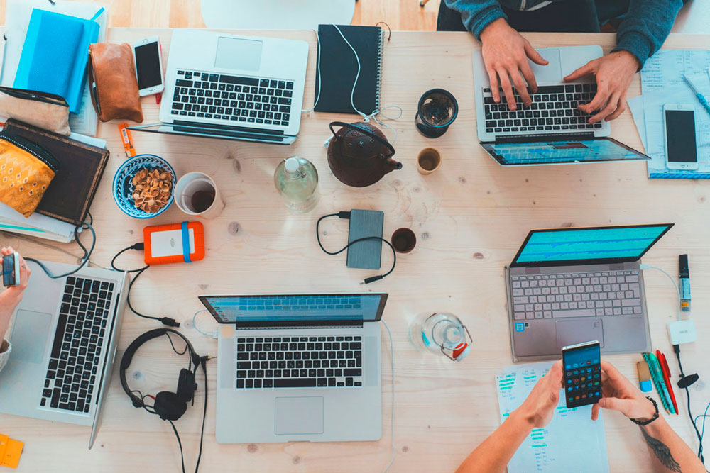 Table vue du dessus recouverte d’outils de communication, ordinateurs, smartphones 