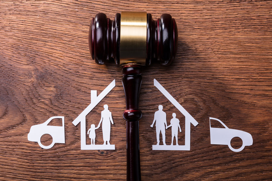 Famille, maison et voiture coupées en deux par un marteau symbolisant la séparation et le divorce