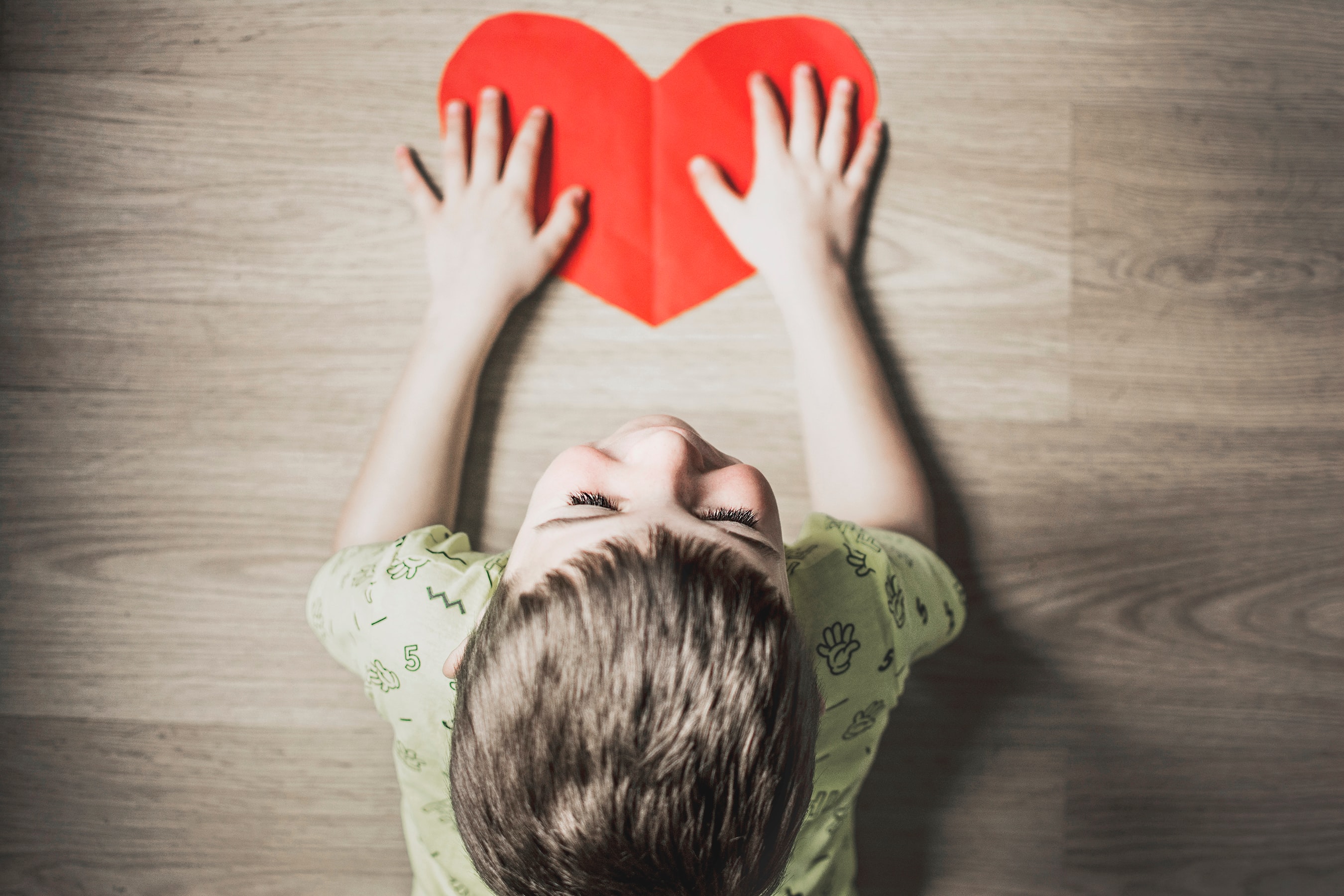 Photo d'un enfant avec un coeur (pas un vrai, un en papier) dans les mains