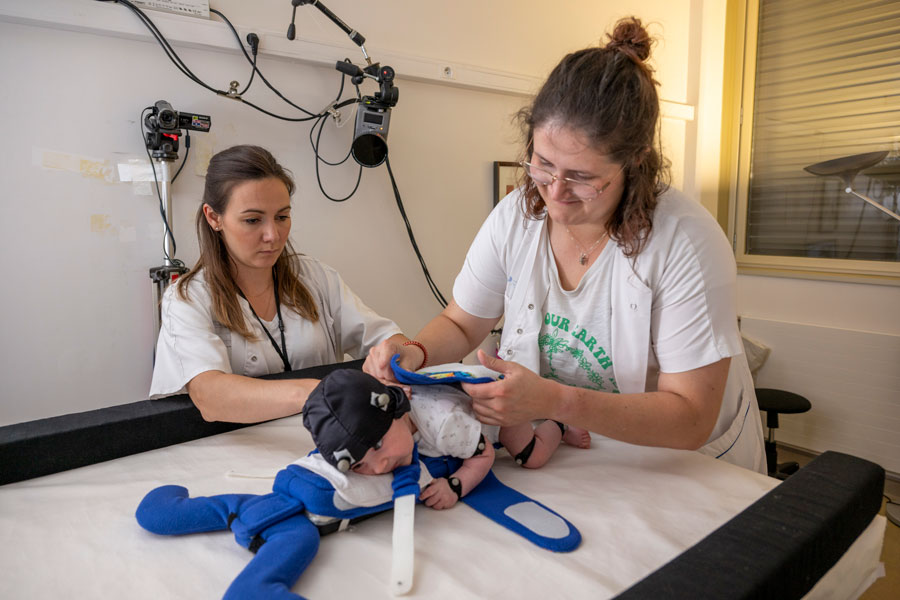 Installation d'un bébé de deux mois sur un crawliskate, une mini planche à roulettes
