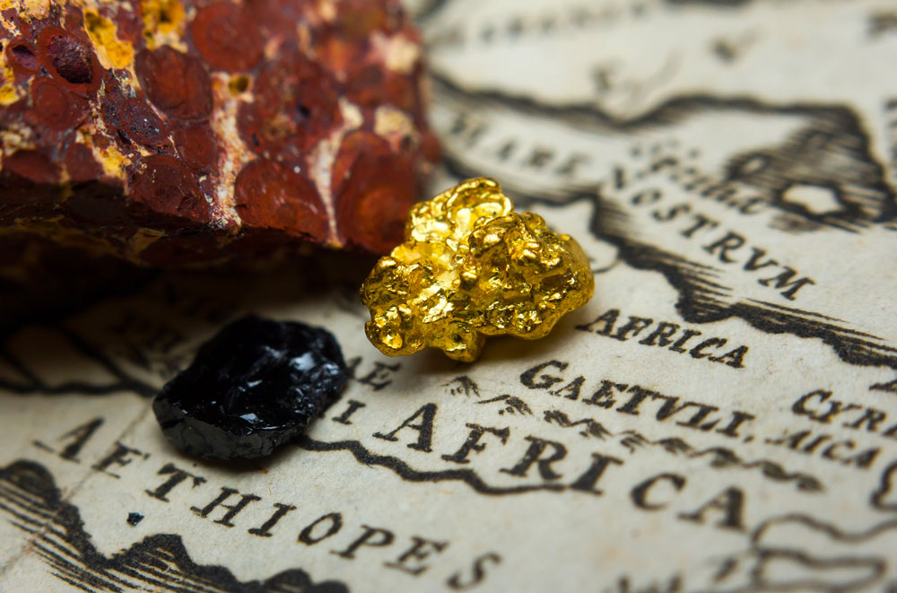 Gros plan sur des minéraux (or, bauxite et charbon) sur une carte de l’Afrique