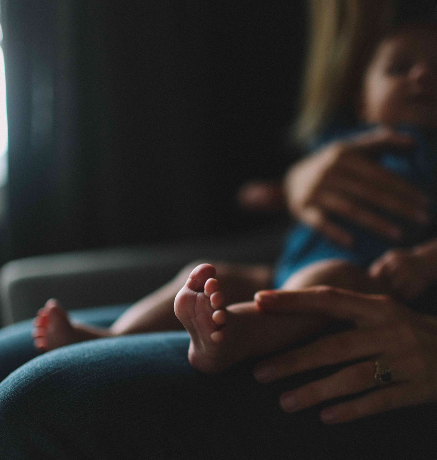 Un enfant sur les genoux d’une personne. Photo by Jenna Norman on Unsplash 