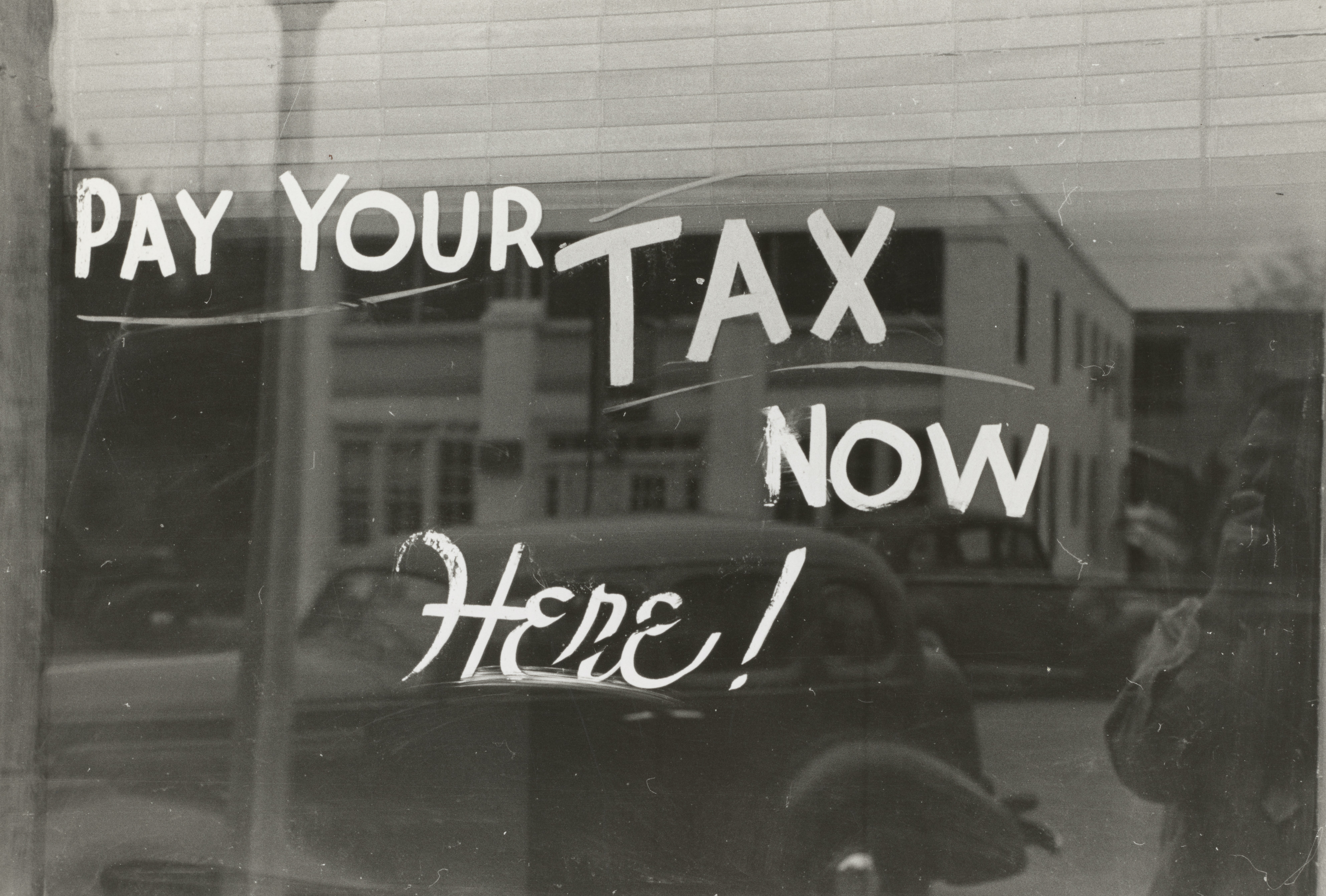 Photo d'une vitrine proclamant "Pay your tax now here !"