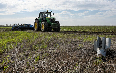 Un missile planté dans un champ cultivé où progresse un tracteur, Zaporijia, au sud-est de l'Ukraine.