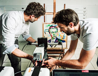Installation d’une caméra particulière, un imageur multispectral de photoluminescence, par deux chimistes du patrimoine ; au fond on voit un tableau de R. Delaunay.