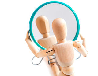 Bonhomme articulé en bois regardant son reflet dans un miroir © GIOIA Photo / Shutterstock.com