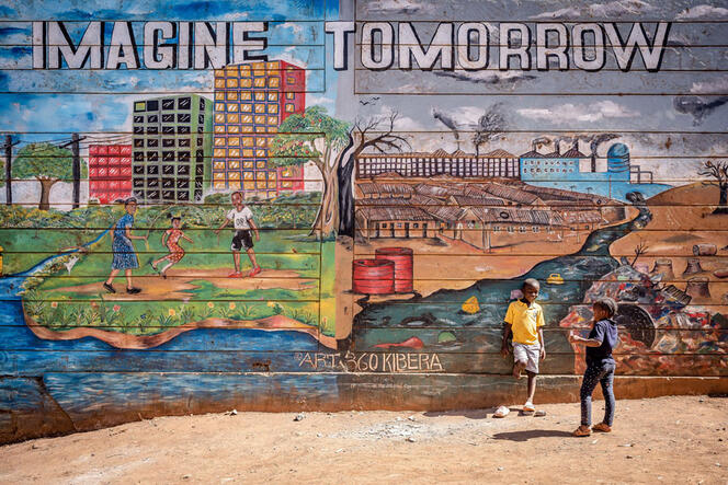 Nairobi, Kenya, 3 février 2023. Des enfants jouent devant une fresque dans le bidonville de Kibera où il est écrit «Imagine Tomorrow» (Imagine demain).