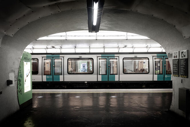 Couloir de la station de métro Nation, à Paris, d'où l'on voit une rame à quai en sous-sol