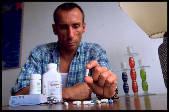 Malade avec tous ses médicaments (antiproteases et antiviraux) posés sur une table devant lui, en 1997.