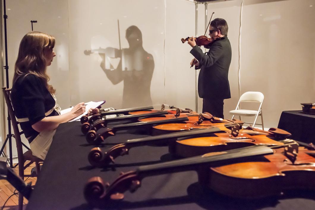 Le violoniste Aaron Boyd en train de tester des violons