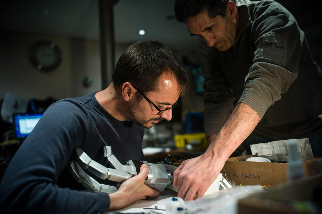 Un ingénieur manipule une main robotisée.