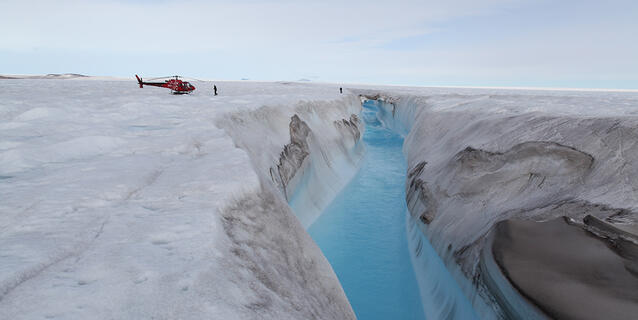 ©Romain MILLAN / Anders Anker BJØRK / IGE / University of Copenhagen / CNRS Images Hélicoptère posé près d’une rivière drainant un lac formé à la surface du glacier de Zachariæ Isstrøm, au nord du Groenland. © Romain MILLAN / Anders Anker BJØRK / IGE / University of Copenhagen / CNRS Images