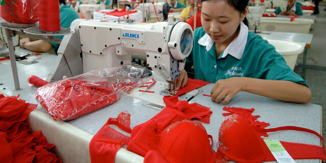 ©Richard Jones / Sinopix-RÉA Une femme coud un soutien-gorge rouge dans usine textile en Chine.