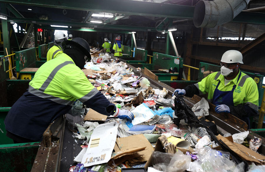 Deux personnes séparent les déchets dans un centre de tri américain.