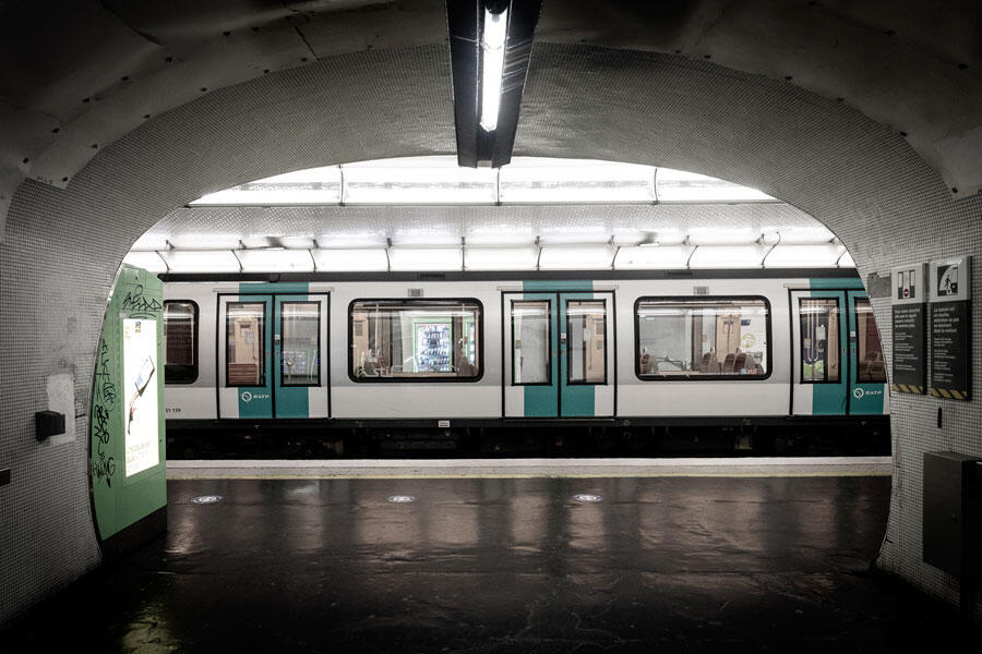 Couloir de la station de métro Nation, à Paris, d'où l'on voit une rame à quai en sous-sol