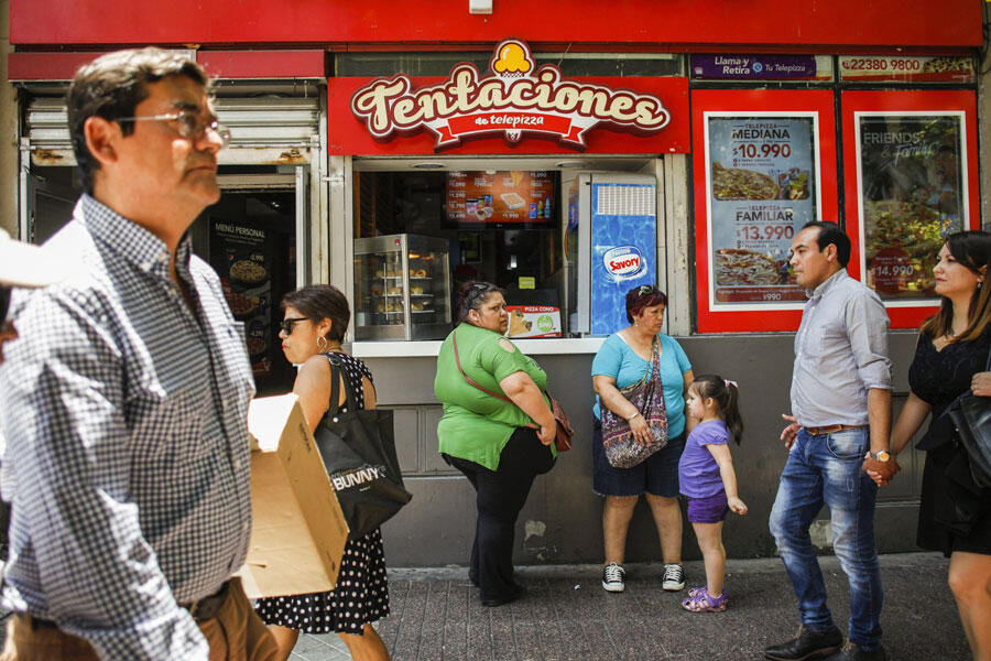 Des clientes devant un fast food vendant des pizzas, à Santiago du Chili