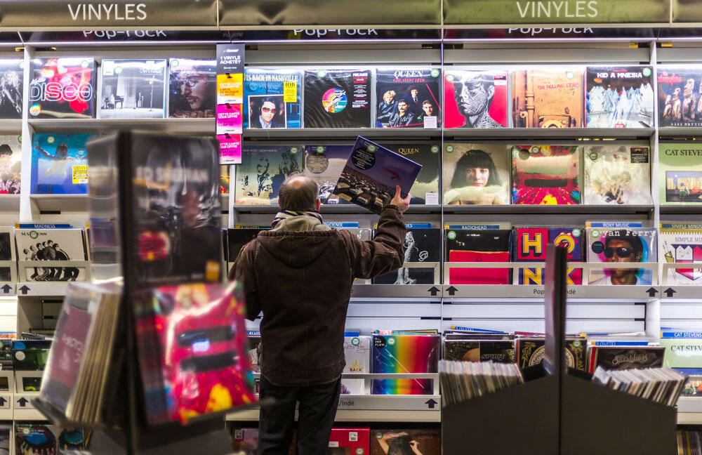 Une personne range des disques vinyles dans un magasin.