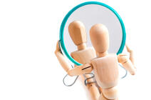 Bonhomme articulé en bois regardant son reflet dans un miroir © GIOIA Photo / Shutterstock.com