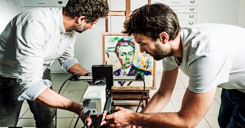 Installation d’une caméra particulière, un imageur multispectral de photoluminescence, par deux chimistes du patrimoine ; au fond on voit un tableau de R. Delaunay.