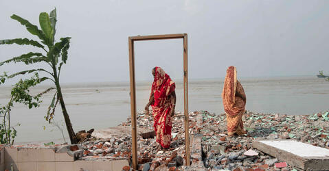 Deux femmes se tiennent sur les restes d’une maison détruite par l’érosion en bordure du fleuve Padma, Bangladesh