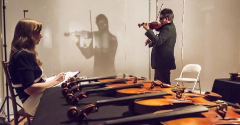 Le violoniste Aaron Boyd en train de tester des violons