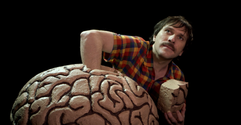 Homme qui plonge sa main dans un cerveau géant
