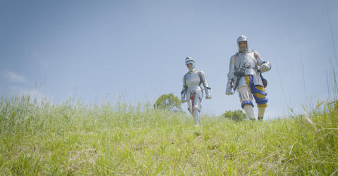 Deux personnes en armures de chevaliers qui marchent