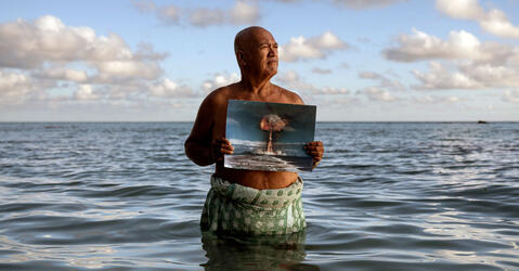 Angelo Tehuira-Hioe, 64 ans, tient une photo d’une explosion nucléaire © Adam Ferguson / The New York Times-Redux / RÉA