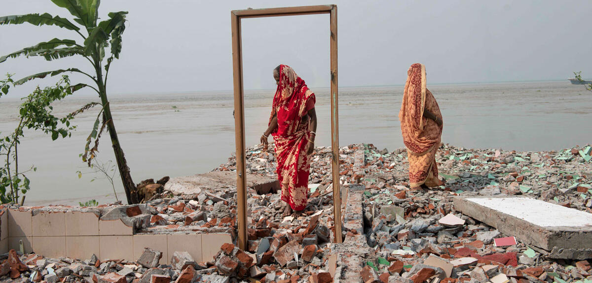 Deux femmes se tiennent sur les restes d’une maison détruite par l’érosion en bordure du fleuve Padma, Bangladesh
