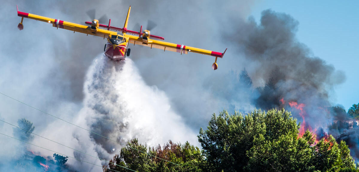 Un canadair se déleste de sa réserve d’eau sur une forêt en feu