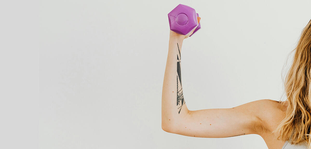 Le bras d’une sportive tenant une haltère violette. Photo Karolina Grabowska/Pexels.com