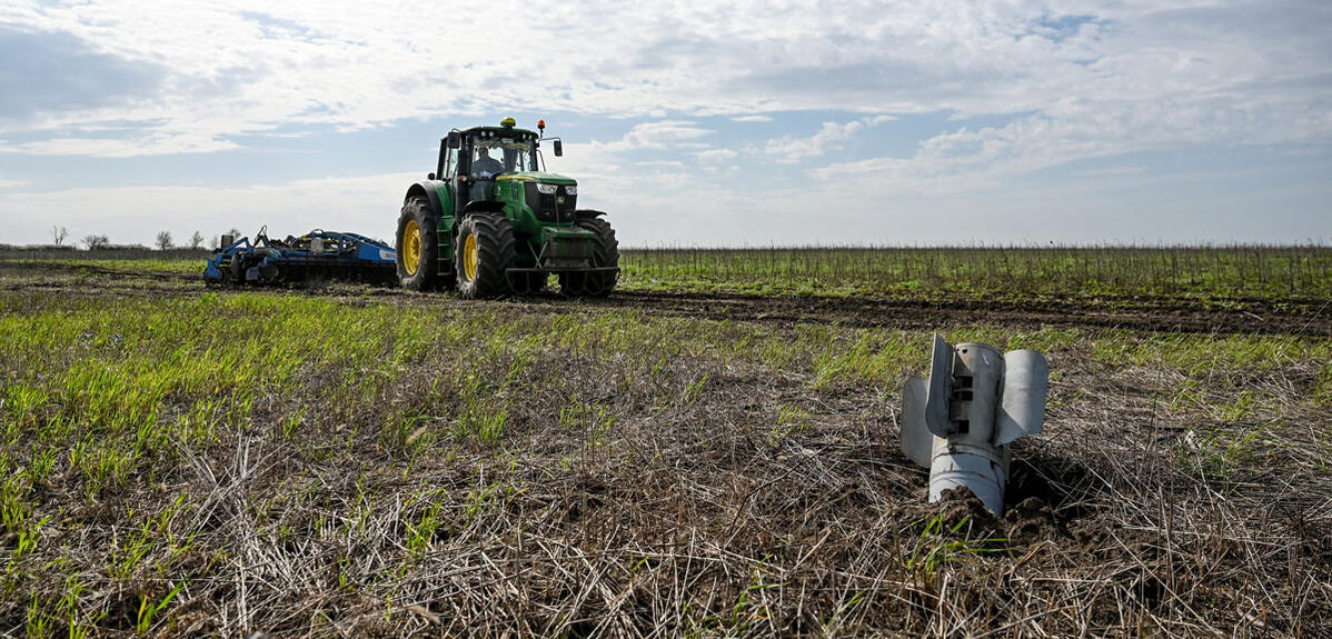 Un missile planté dans un champ cultivé où progresse un tracteur, Zaporijia, au sud-est de l'Ukraine.