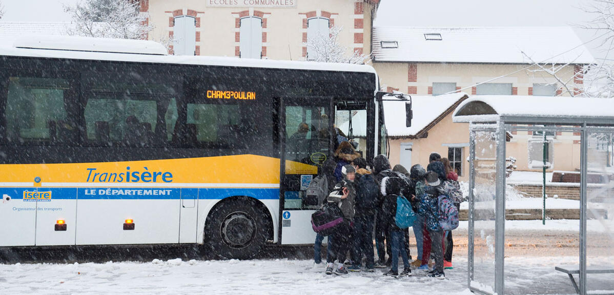 Transport scolaire : bus en hiver sous la neige, à Maubec, en Isère (région Auvergne Rhone Alpes). 