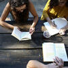 Des personnes lisent des livres sur une table en bois
