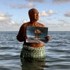 Angelo Tehuira-Hioe, 64 ans, tient une photo d’une explosion nucléaire © Adam Ferguson / The New York Times-Redux / RÉA